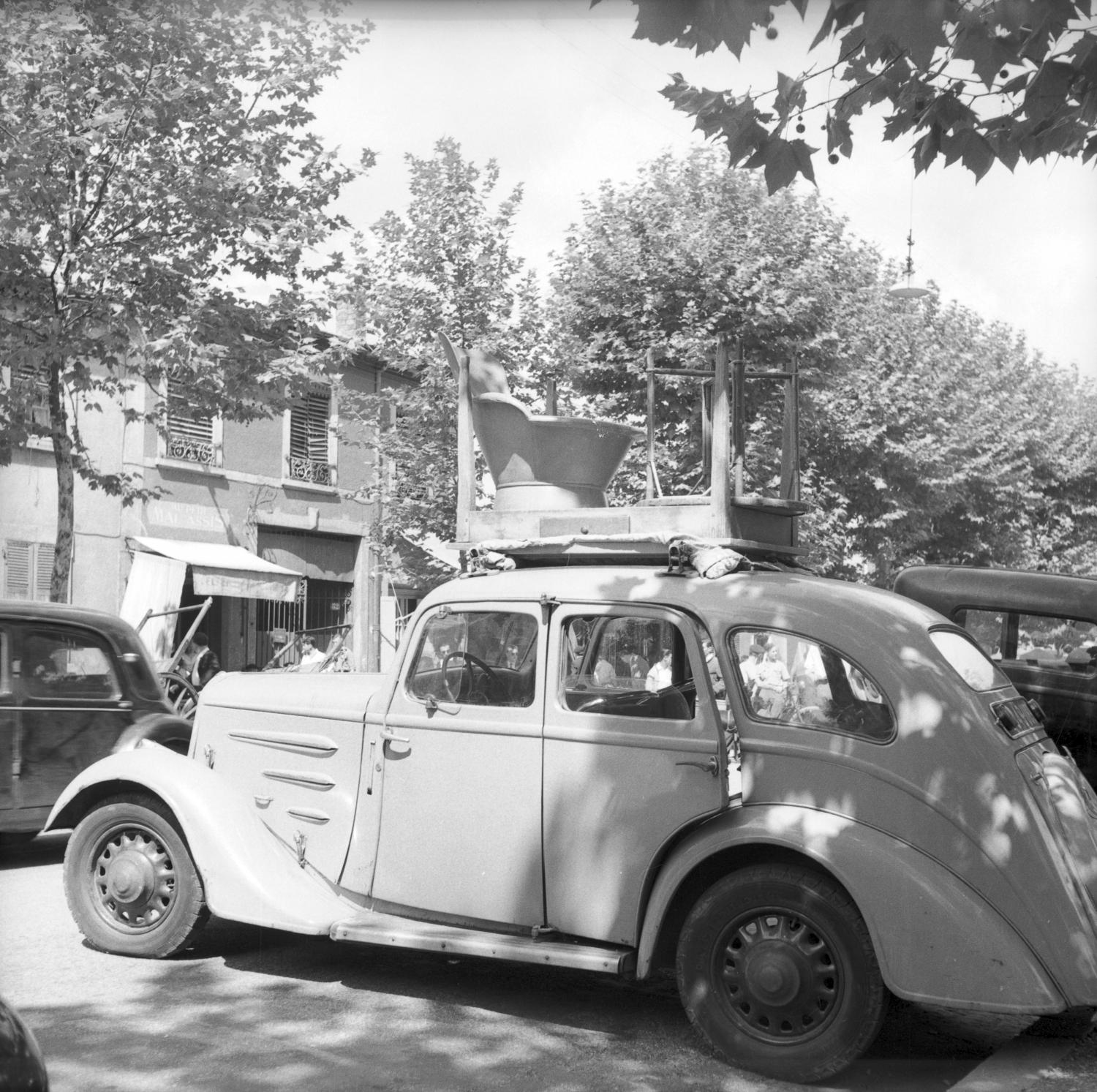 [Voiture ancienne avec des meubles empilés sur le toit]