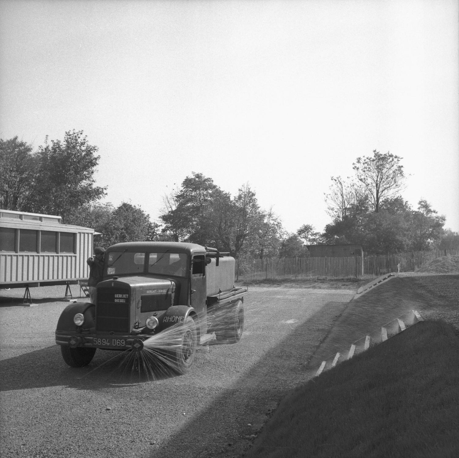 [Un camion industriel arrose la pelouse]