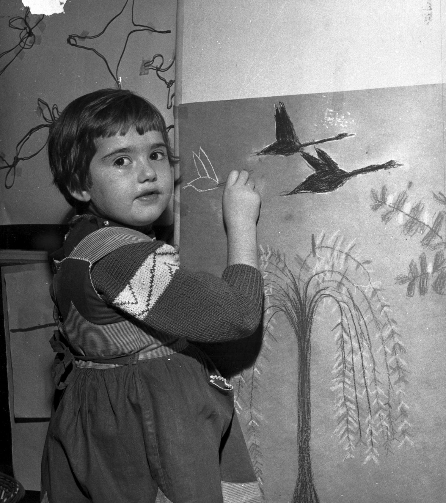 [Une petite fille dessine un dernier oiseau sur sa toile]