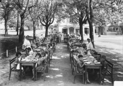 [Repas d'enfants en plein air, sous la surveillance de religieuses]