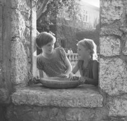 [Deux filles posent dans l'encadrement d'une fenêtre]