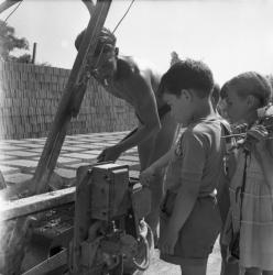 [Un groupe d'enfants observe un adulte travailler]